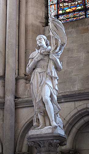 Statue of Joan of Arc Holding her Flag with her arm crossed across her heart