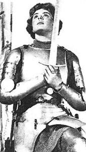 Joan kneels while holding her sword